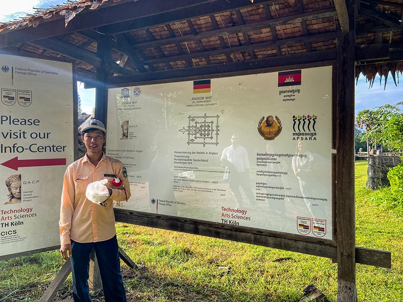 Mr. Ratanak zeigt uns ein Schild mit Informationen zur Restaurationsarbeiten von Angkor Wat
