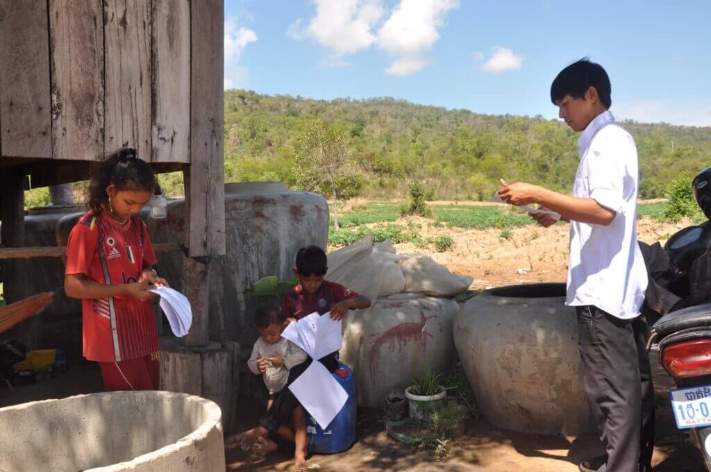 Heang explaining the homework to the students at their most distanced home.